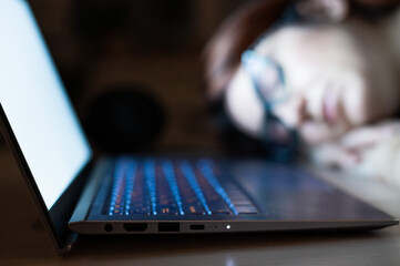 The exhausted employee worked overtime and fell asleep at his desk. Deadline Work at night with a laptop. The student is preparing for the exam.