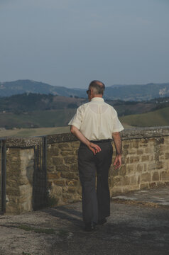 A statuesque man walks through a castle in Italy, Bertinoro