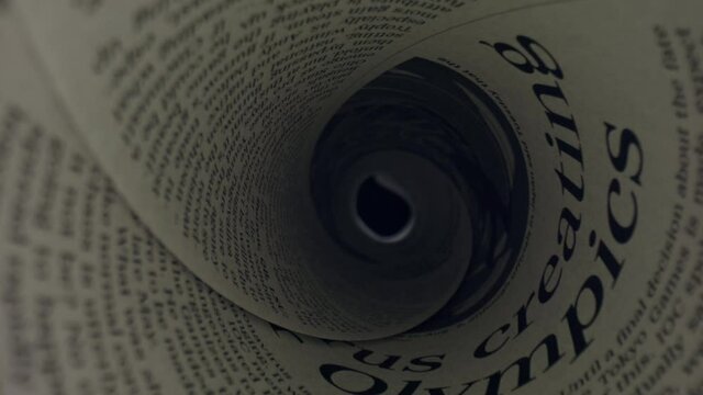 Rolled newspaper with headline news. Camera moving through folded newspaper