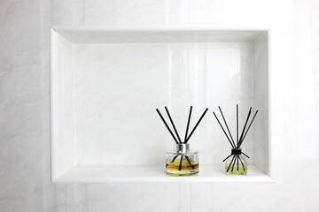 luxury glass aroma scent reed diffuser bottles with yellow oil are displayed in the nice white toilet bahtroom