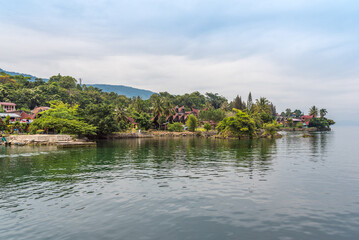 Obraz premium The island Samosir and peninsula Tuktuk Siadong with its resorts, within the Lake Toba, the biggest volcanic lake in the world located in the middle of the northern part of the island of Sumatra 