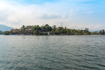 Fototapeta premium The island Samosir with the peninsula Tuktuk Siadong within the Lake Toba, the biggest volcanic lake in the world located in the middle of the northern part of the island of Sumatra 