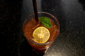 Lemon and spearmint in ice tea with dark background.