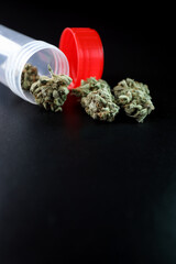 Small box full of cannabis and tobacco on a black background. Marijuana legalization. Medical cannabis. Drug addiction.