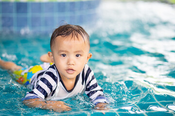 Little adorable boy in swimming suit enjoying swimming  in the pool