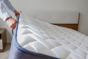 New bed delivery and assembly service concept. Cropped shot of male worker's hands in process of...