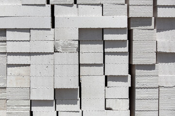 Aerated concrete blocks of light building material of white color piled on a pile for construction, texture closeup nobody.