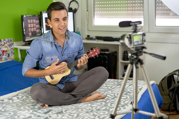 youtuber recording himself while playing the ukulele