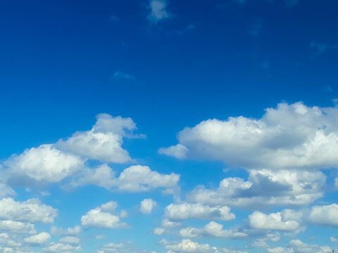 White fluffy clouds in the blue sky. Summer, cloudy. The air, the atmosphere.