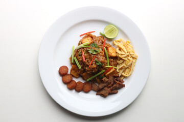 Closeup Pad Mee Korat (Stir-Fried Noodle Thai Korat style) served on a white plate Put on the white table Ready to eat Taken from above