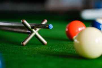 Man's hand and Cue arm playing snooker game or preparing aiming to shoot pool balls on a green...
