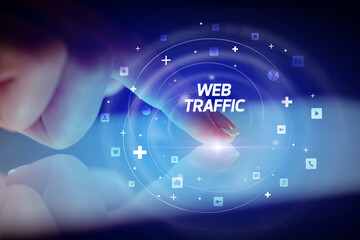 Finger touching tablet with social media icons and WEB TRAFFIC