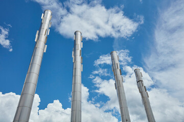 four smokestacks on a background of a beautiful blue sky and white clouds