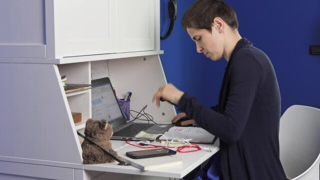 Young woman works in smart working. He looks at the laptop screen and is bored.