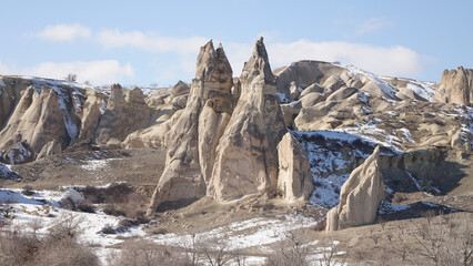 Cappadocia cone-shaped rock formations near the city of Göreme with snow during winter in central Turkey.