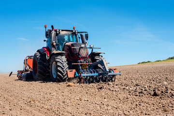 Fototapeta premium farmer in his tractor sowing in the fields