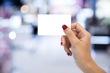 Girl holding white card In the middle of the mall to find the right item