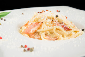 Italian pasta. Pasta in a creamy sauce. Pasta with bacon. Pasta on a white plate