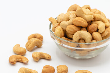 Tasty cashew nuts in the glass bowl on white background, A food that is beneficial to health Eaten as a snack is tasty and contains vitamins K, E, B6, Phosphorus, Magnesium and antioxidants.