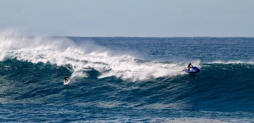 Surfeur australien faisant du surf tracté par un jetski sur une vague géante près de Sydney en Australie