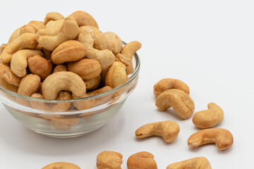 Tasty cashew nuts in the glass bowl on white background, A food that is beneficial to health Eaten as a snack is tasty and contains vitamins K, E, B6, Phosphorus, Magnesium and antioxidants.