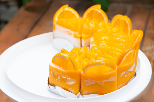 A Lot Of Real Orange Cake Wrap By Foil And Plastic On White Plate And Wood Table Stock Photo