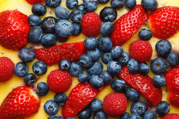 cheesecake with strawberries and blueberries, close-up view