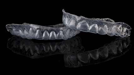 beautiful flexible dental capsule of the upper and lower jaw, shot on a black background with reflection