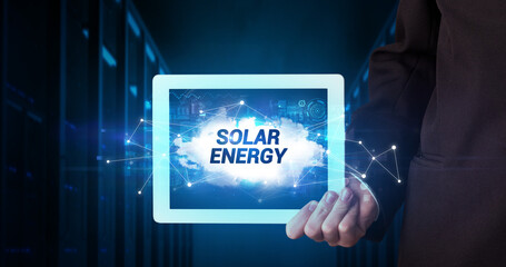 Young business person working on tablet and shows the inscription: SOLAR ENERGY