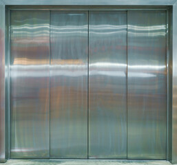 Front view of silver metal elevator with closed doors.