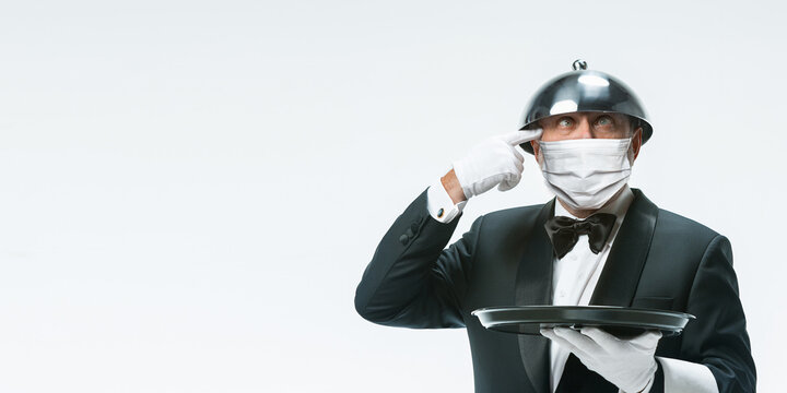 Healthcare. Elegance senior man waiter in protective face mask on white background. Flyer with copyspace. Cafe, restaurant opening. Safety during coronavirus pandemic. Taking care of guests, clients.