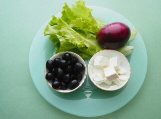 Greek salad with tomatoes, cucumbers, peppers, olives, feta cheese, and red onions with olive oil