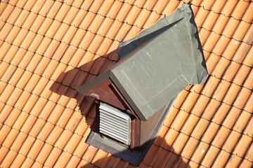 Close-up of small vent on the red tile roof.