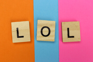 LOL - Laugh Out Loud of wooden letters on a colored striped background