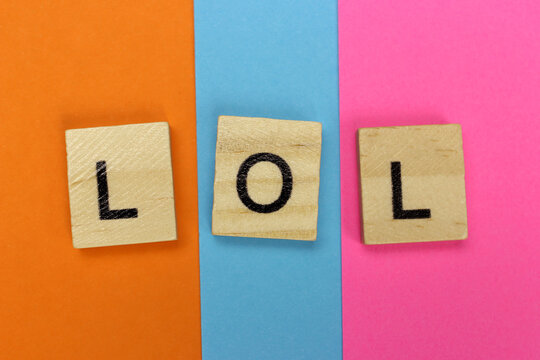 LOL - Laugh Out Loud of wooden letters on a colored striped background