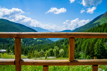 Fototapeta premium Wooden vintage fence and blurred background of nature mountain's meadow landscape background with sunny day. Travel and holidays.