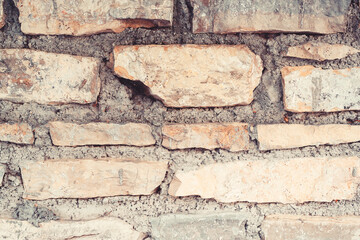 Old weathered brick wall, closeup. Grunge dirty old brick stone wall exterior. Ancient temple architecture.