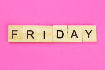 word Friday made of wooden letters on a pink background