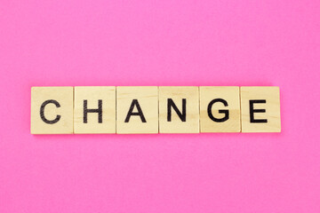Word change from wooden letters on a pink background