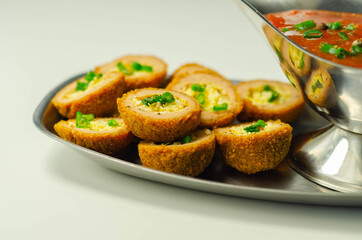 Mini scotch eggs with tomato sauce served on the silver plate