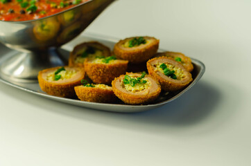 Mini scotch eggs with tomato sauce served on the silver plate