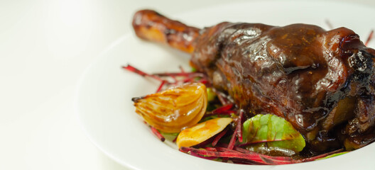 Delicious Lamb shank with red wine and rosemary gravy served on the mixed leaf salad