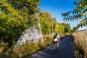 Cyclist rides on the Toronto rail path on summer afternoon