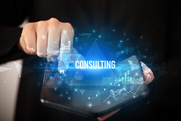 Businessman holding a foldable smartphone with CONSULTING inscription, business concept