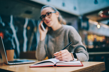 Woman preparing to exams using notepad during e learning with laptop computer