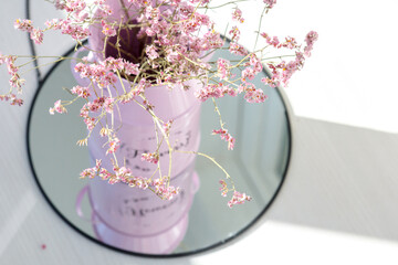 dried flowers in a vase, pink twigs, flowers on a round mirror
