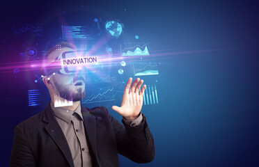 Businessman looking through Virtual Reality glasses with INNOVATION inscription, new business concept