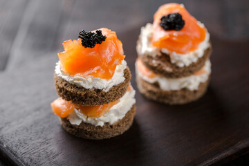 Smoked salmon with creamy cottage cheese and black caviar. Catering finger food, snack, mini...