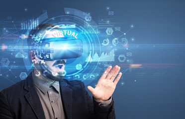 Businessman looking through Virtual Reality glasses with VIRTUAL inscription, innovative technology concept