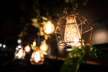 An antique lighting chandelier for decorate room interior with blurred bokeh of many lighting bulbs as backgound.